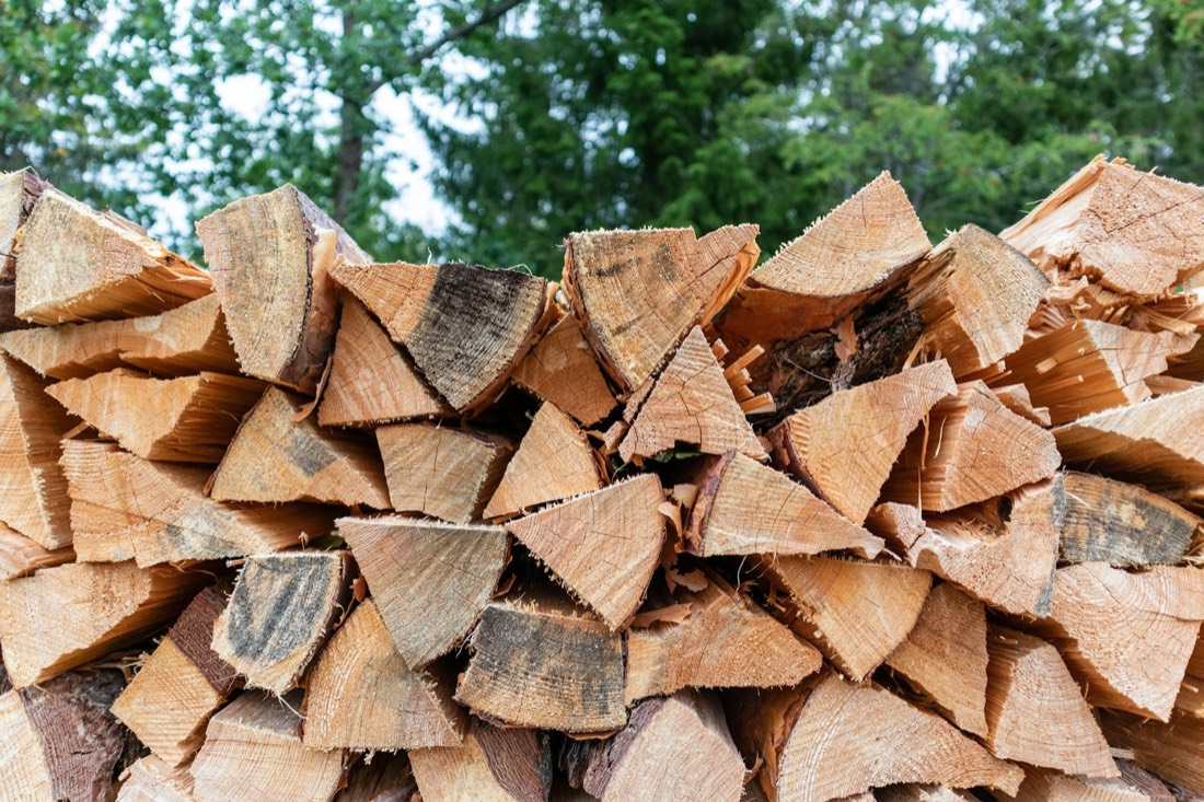 Tas de bûches de bois de chauffage fendu, stocké en extérieur